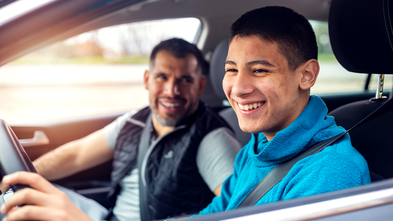 8 ideias para tirar seu pai do sufoco financeiro: filho dirigindo com o pai no passageiro