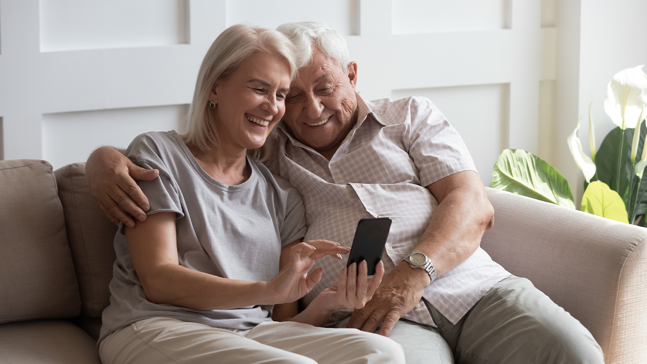  Como ajudar idosos de sua família ou grupo de amigos a se protegerem de golpes e fraudes: casal de idosos mexendo no celular