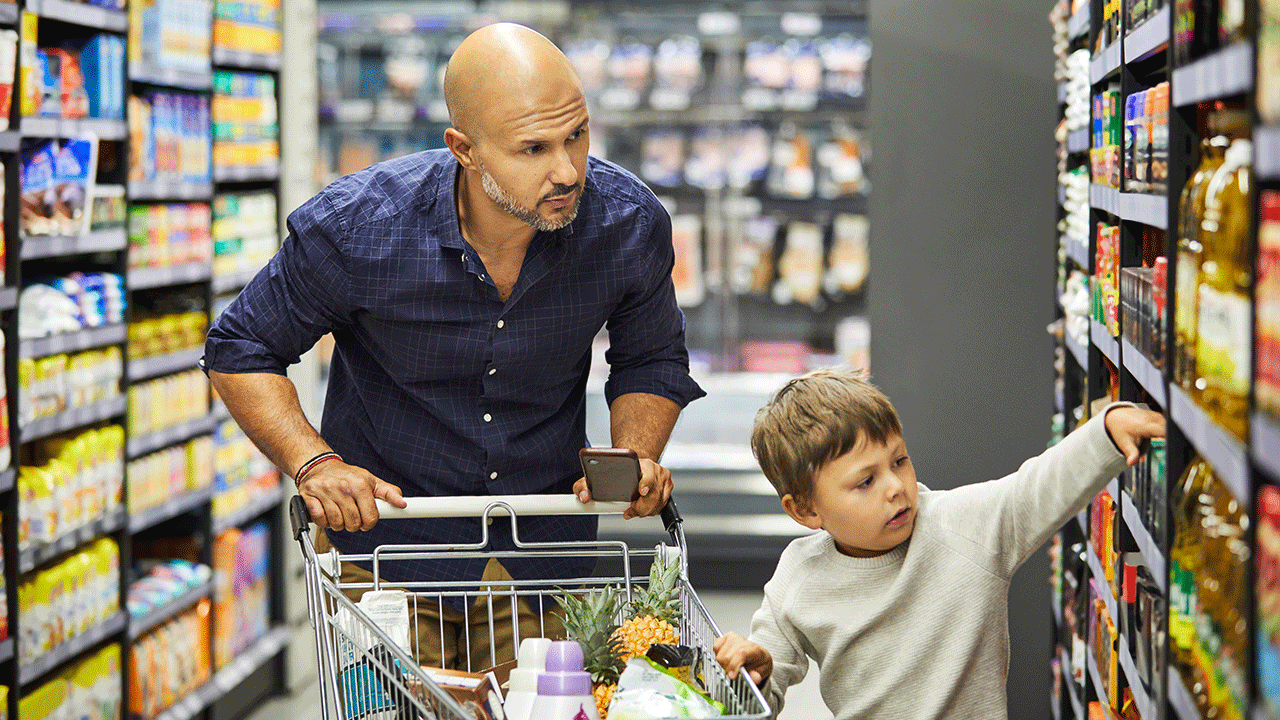 Porque é importante criar bons hábitos financeiros e disciplina para poupar: pai acompanha a escolha do filho no supermercado