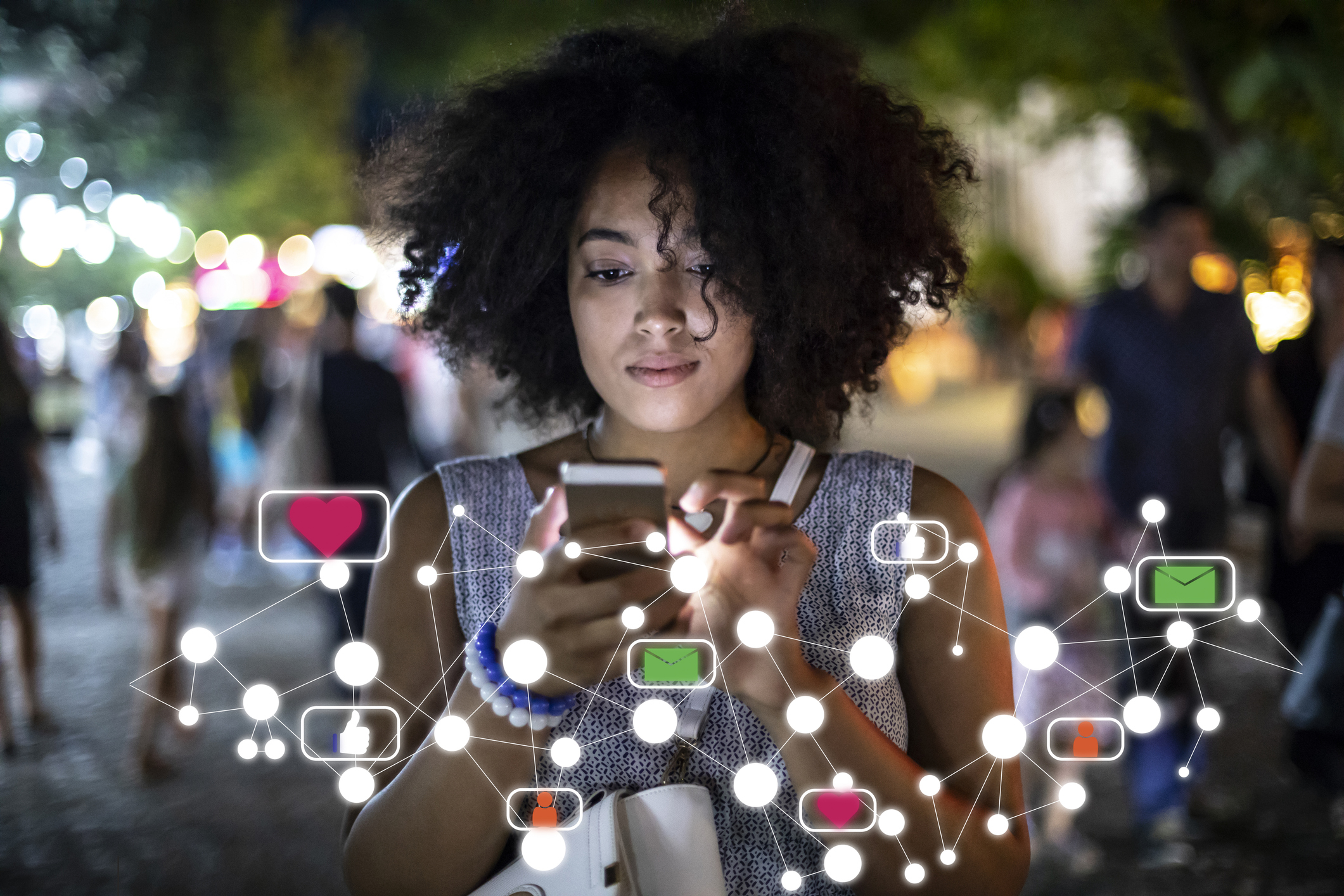 Matéria MBeD - Como ganhar dinheiro com redes sociais - Mulher negra segura iphone na mão enquanto faz suas conexões nas redes sociais e e-mail, ícones em rede representam reações e ligações nas redes sociais