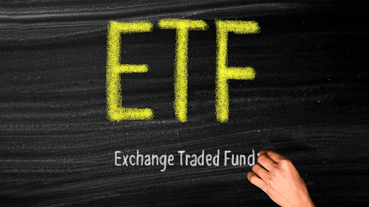 ETF's, fundos de investimentos: pessoa escreve com giz a sigla ETF, e, abaixo, seu significado