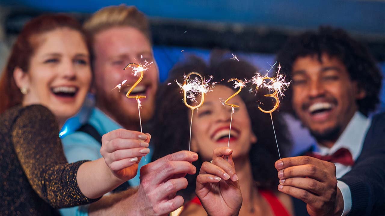 Pessoas comemorando o ano novo de 2023 no texto que mostra como se organizar financeiramente